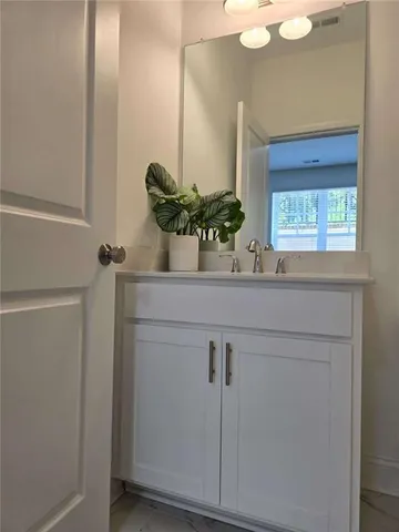 a view of an empty room with wooden floor and windows