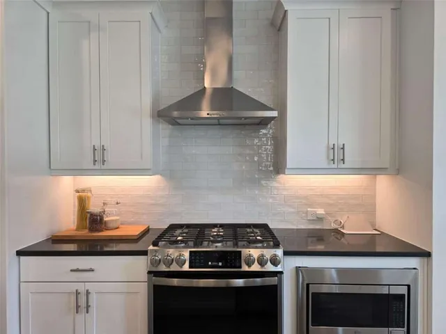 a stove top oven sitting inside of a kitchen
