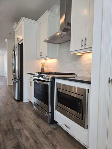 a kitchen with stainless steel appliances a stove a microwave and a refrigerator