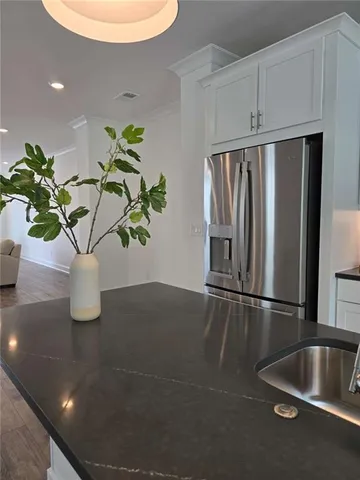 a view of kitchen with stainless steel appliances granite countertop a potted plant