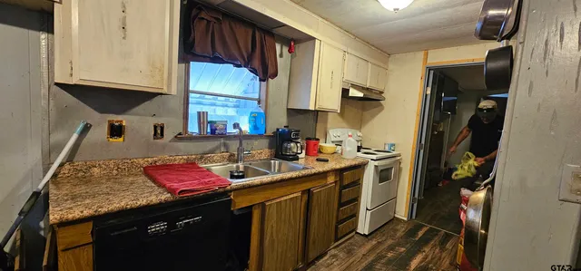 a kitchen with a sink stove top oven and cabinets
