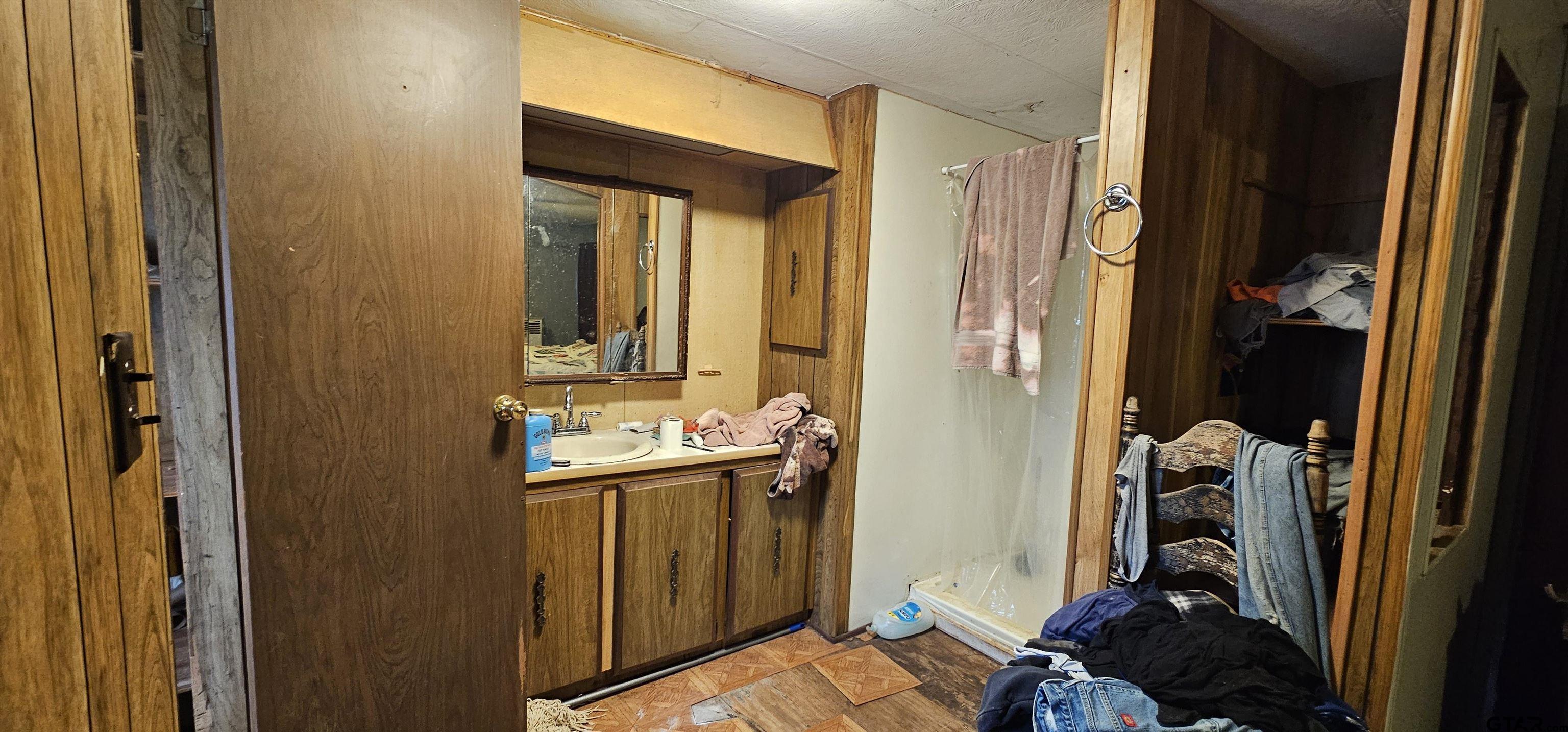 240 Elm Drive Murchison, TX 75778 - Photo 18 of 19 a bathroom with a sink a mirror and a shower