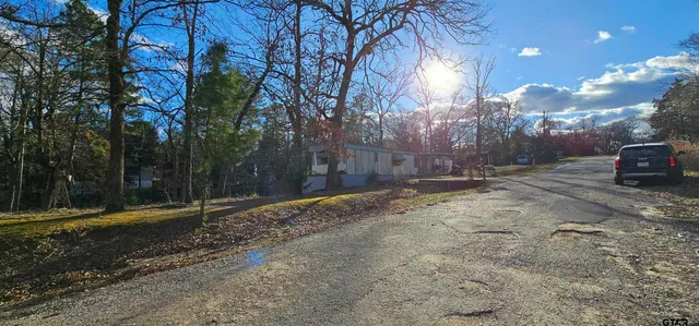 a view of a yard with wooden fence