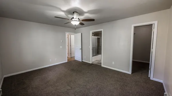 a view of an empty room with a chandelier fan