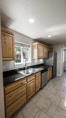 a large kitchen with granite countertop a sink and cabinets