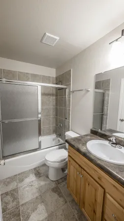 a bathroom with a granite countertop sink toilet and shower