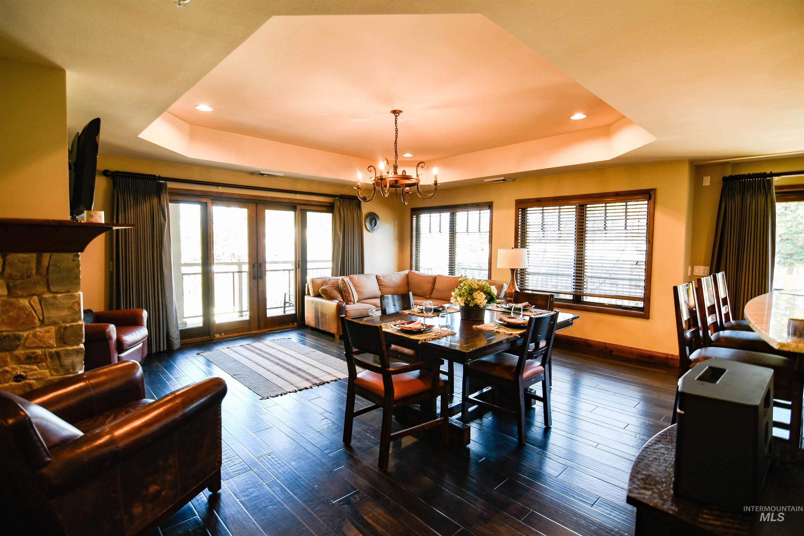 616 North 3rd Street, Unit 215 McCall, ID 83638 - Photo 4 of 36 Dining room with a tray ceiling, dark wood-type flooring, french doors, recessed lighting, and a chandelier