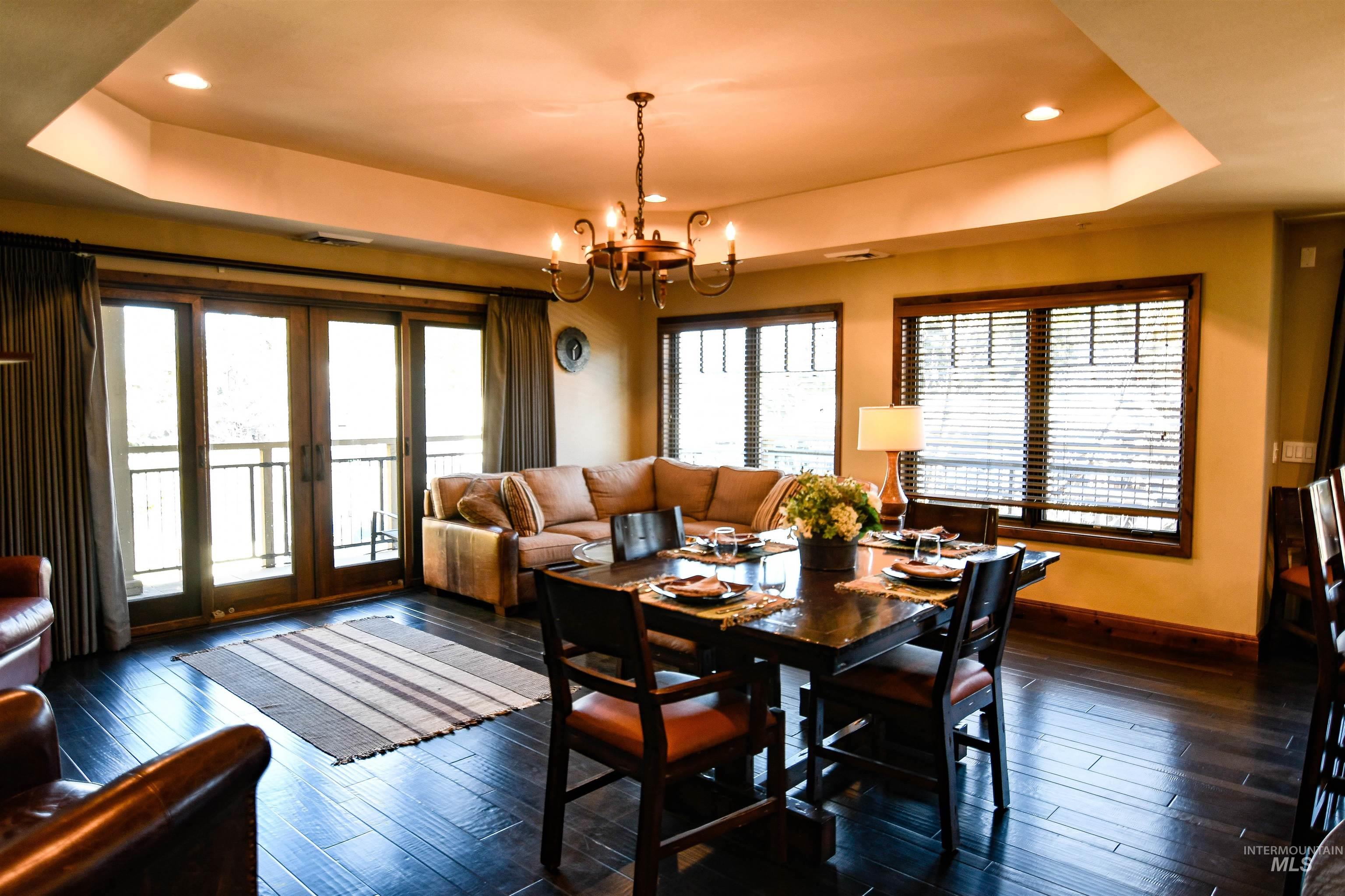 616 North 3rd Street, Unit 215 McCall, ID 83638 - Photo 5 of 36 Dining room with a tray ceiling, french doors, recessed lighting, dark wood-style flooring, and a chandelier