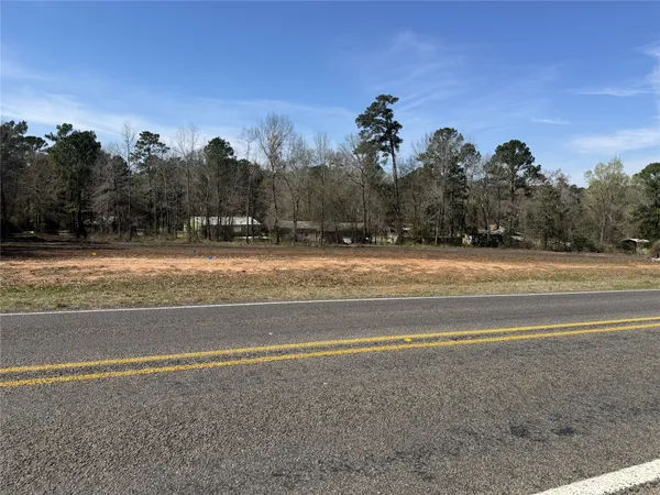 a view of a house with a yard and trees in the background