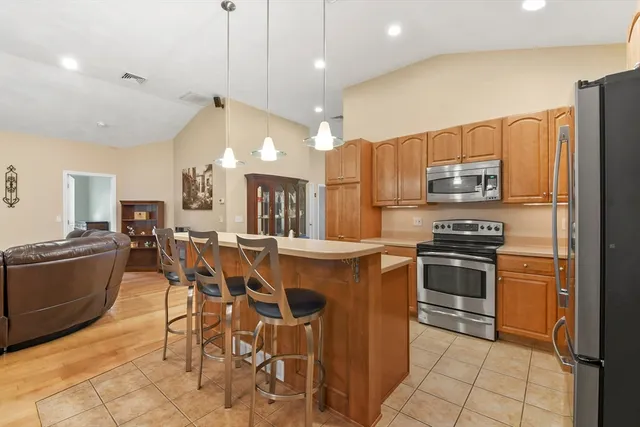 a kitchen with kitchen island a sink appliances and cabinets
