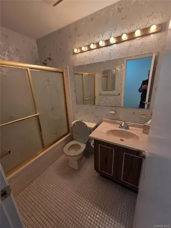 a spacious bathroom with a sink a toilet and mirror