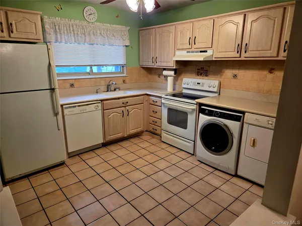 a kitchen with a sink a refrigerator and cabinets