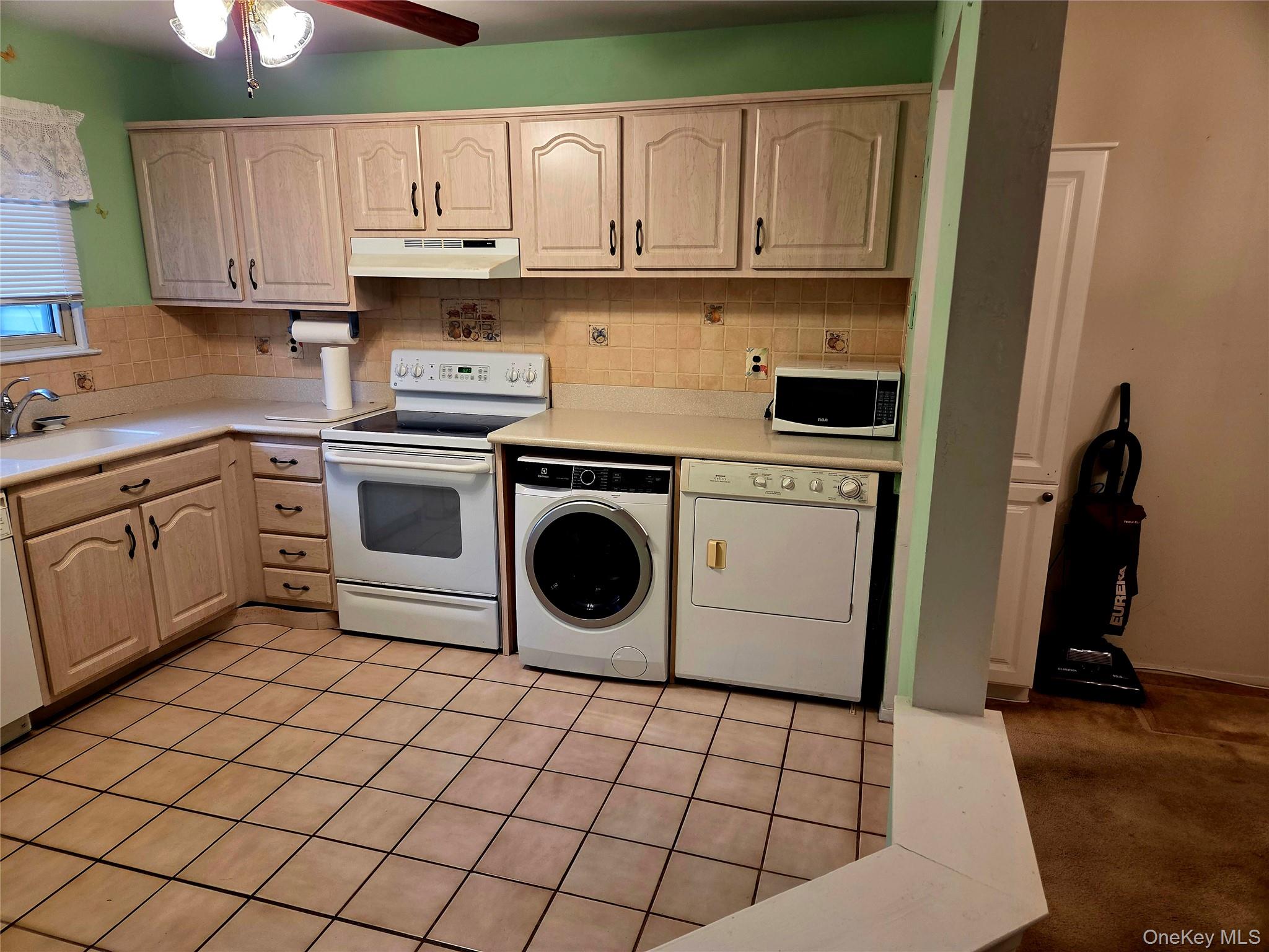 650 Newbridge Road, Unit 36 East Meadow, NY 11554 - Photo 3 of 14 a kitchen with a stove a sink and a refrigerator