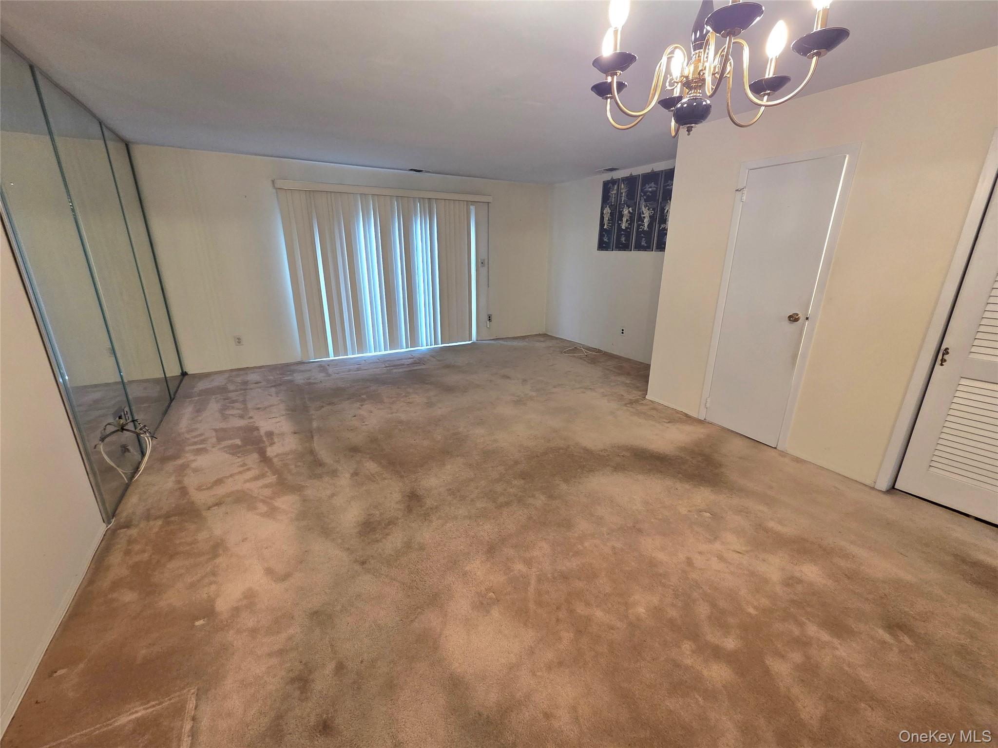 650 Newbridge Road, Unit 36 East Meadow, NY 11554 - Photo 6 of 14 a view of an empty room with a chandelier
