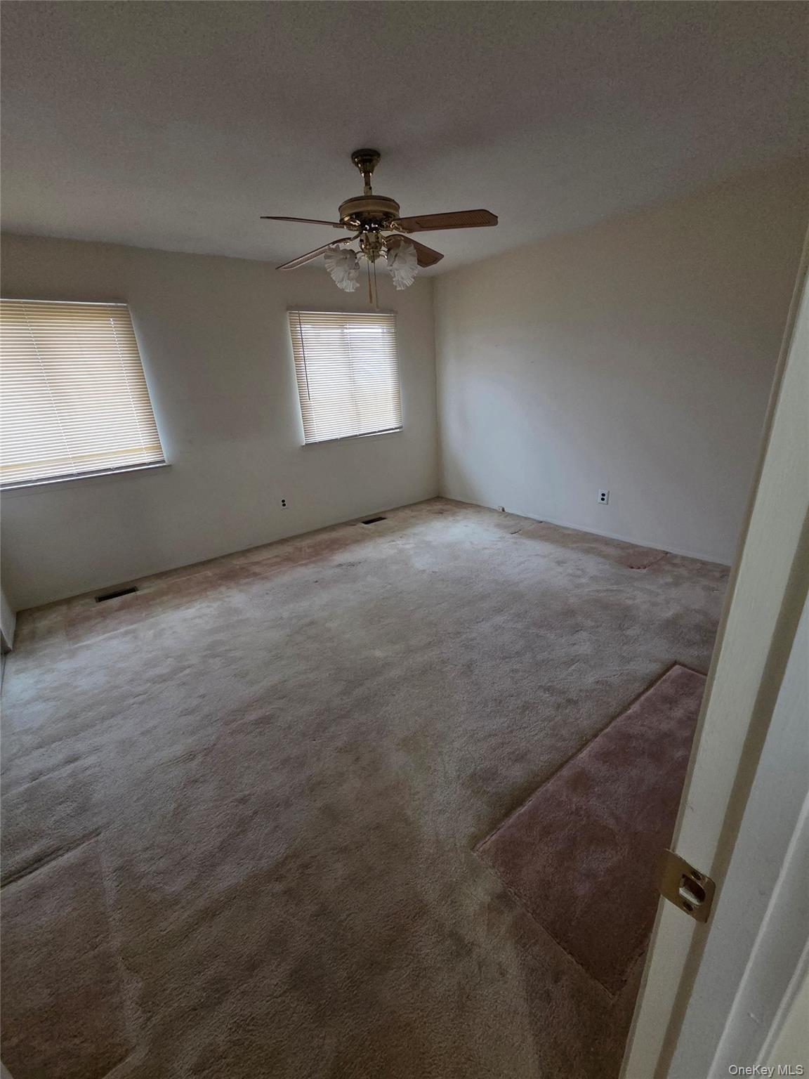 650 Newbridge Road, Unit 36 East Meadow, NY 11554 - Photo 10 of 14 en empty room with windows and ceiling fan