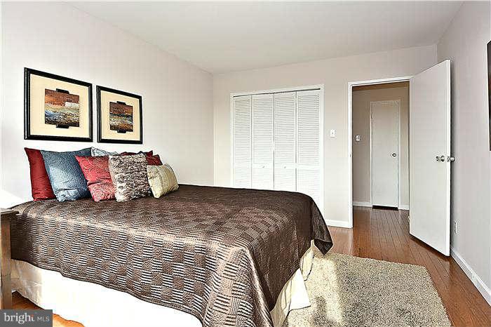1210 North Taft Street, Unit 903 Arlington, VA 22201 - Photo 12 of 21 a bedroom with a bed and wooden floor