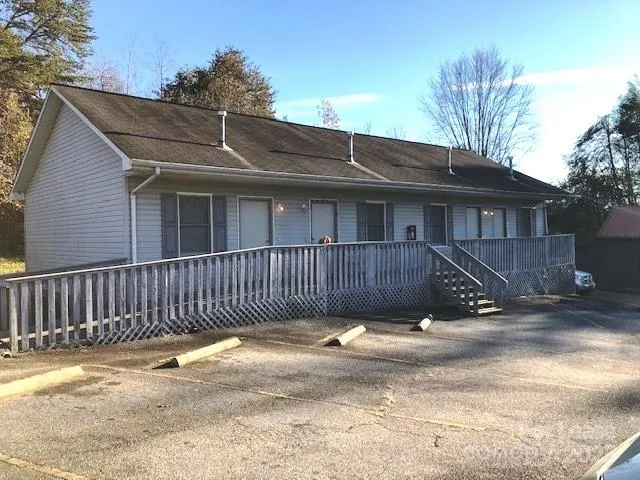 a view of a house with a small yard and wooden fence