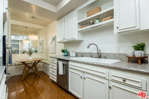 a kitchen with stainless steel appliances granite countertop a stove and a wooden floors