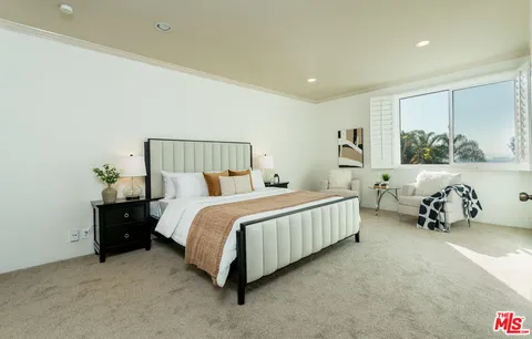 a spacious bedroom with a bed and wall painting