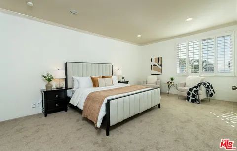 a bedroom with a large bed and a chandelier
