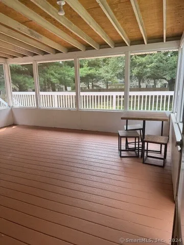 a view of a chairs and table in patio with a wooden fence