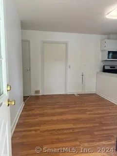 a view of a room with kitchen countertops and wooden floor