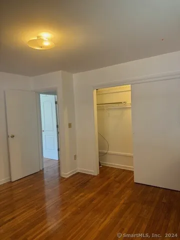 an empty room with wooden floor and closet