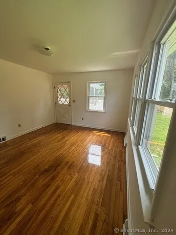 wooden floor in an empty room with a window