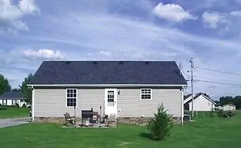 a view of house with backyard