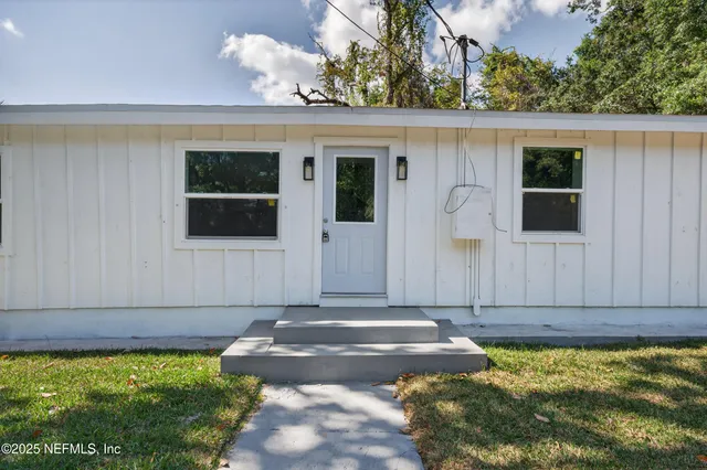 a kitchen with stainless steel appliances granite countertop a stove top oven a refrigerator a sink and dishwasher with white cabinets