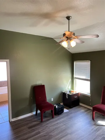 a view of a room with wooden floor lounge chair and windows