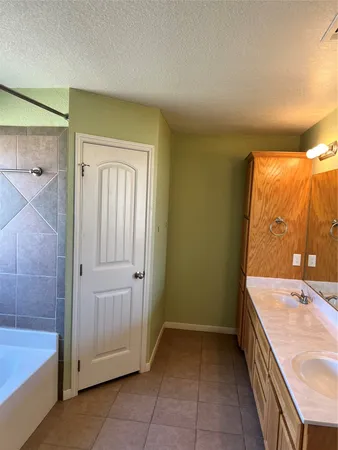 a bathroom with a tub sink and mirror