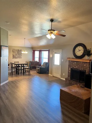 a view of a livingroom with fireplace wooden floor and chandelier