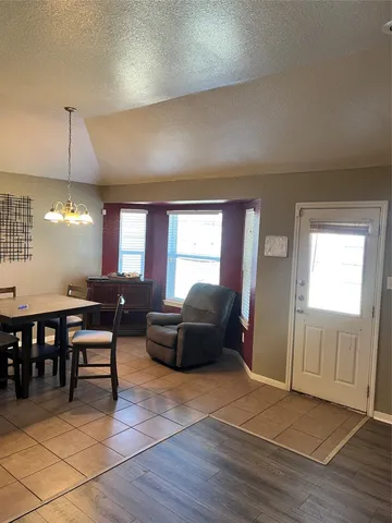 a living room with furniture a dining table and a window
