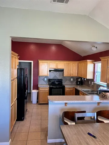 a kitchen with stainless steel appliances granite countertop a refrigerator and a stove