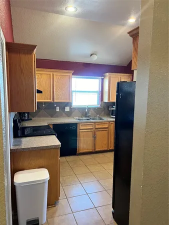 a kitchen with stainless steel appliances granite countertop white cabinets a refrigerator a sink a stove and island