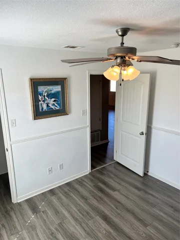 a view of a hallway with wooden floor and chandelier