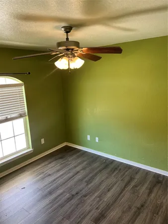a view of empty room with window and wooden floor