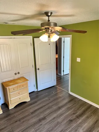 a view of a room with wooden floor and a ceiling fan