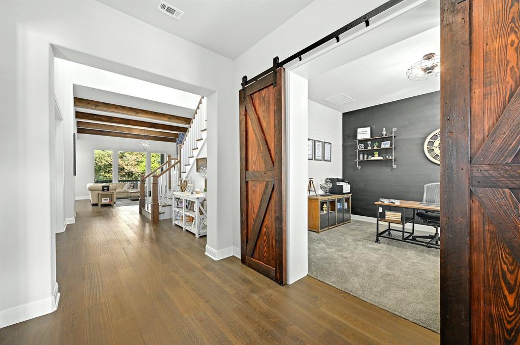629 Germander Road Leander, TX 78641 - Photo 4 of 32 Rich hardwood flooring guides you to a versatile office space, complete with a rustic barn door entry.