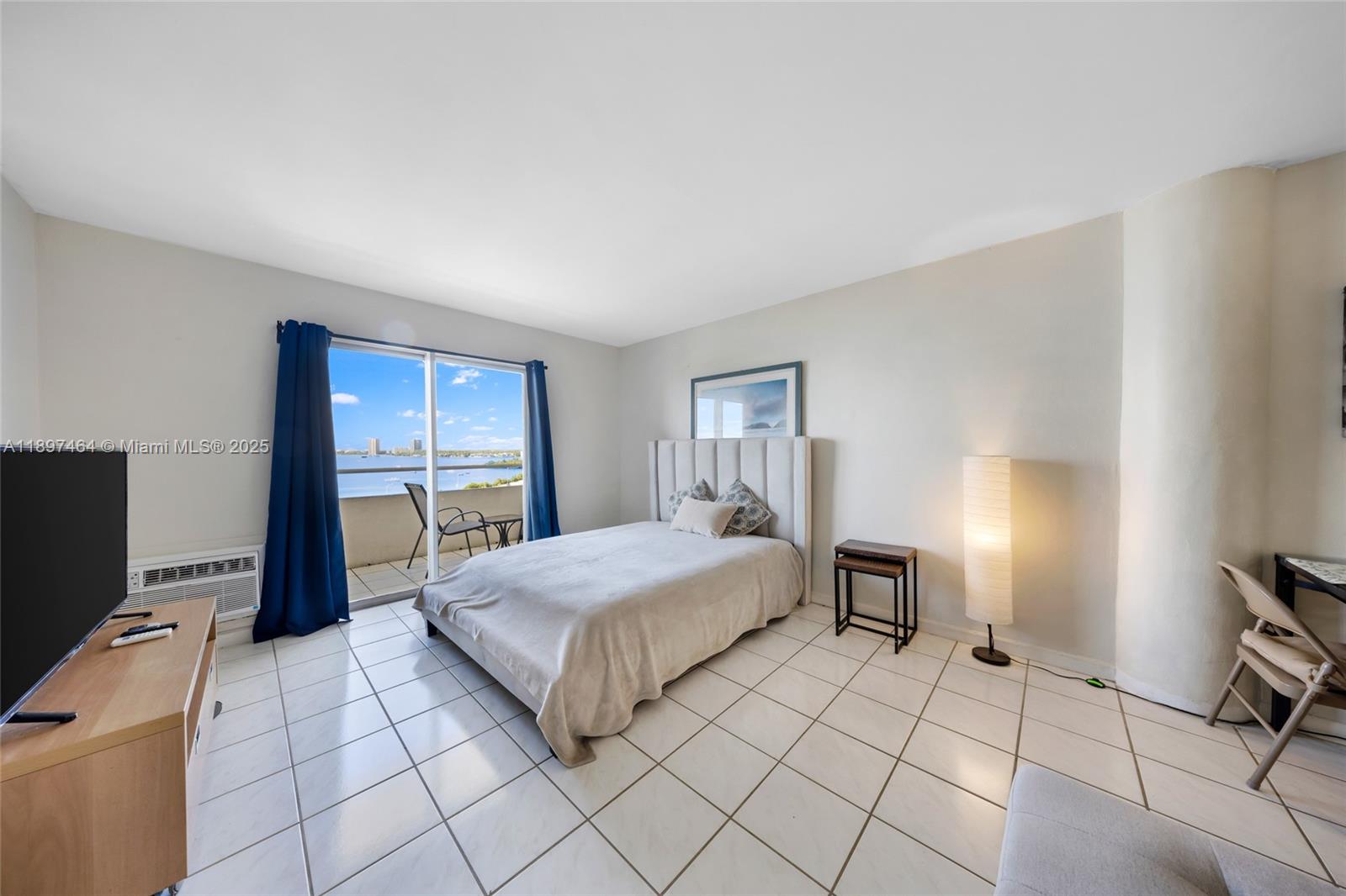 7904 West Drive, Unit 1010 North Bay Village, FL 33141 - Photo 6 of 25 a bedroom with a bed and a tv on table