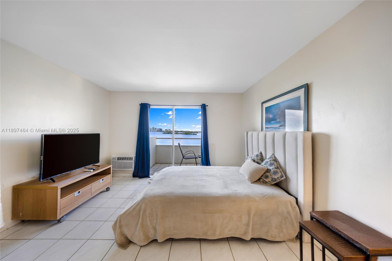 7904 West Drive, Unit 1010 North Bay Village, FL 33141 - Photo 10 of 25 a bedroom with a bed and a flat screen tv