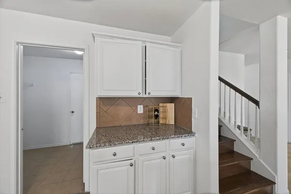 a kitchen with granite countertop a sink a stove and cabinets