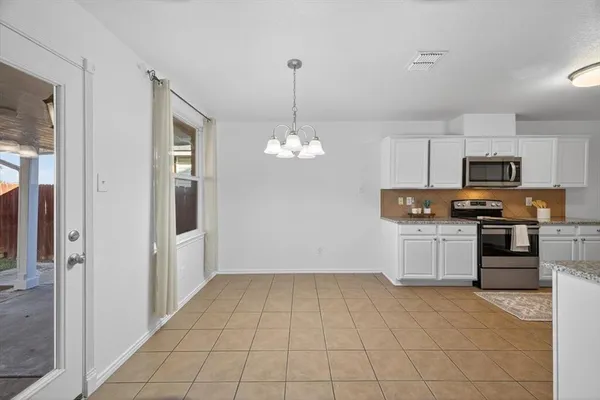 a kitchen with kitchen island granite countertop a refrigerator stove top oven and sink