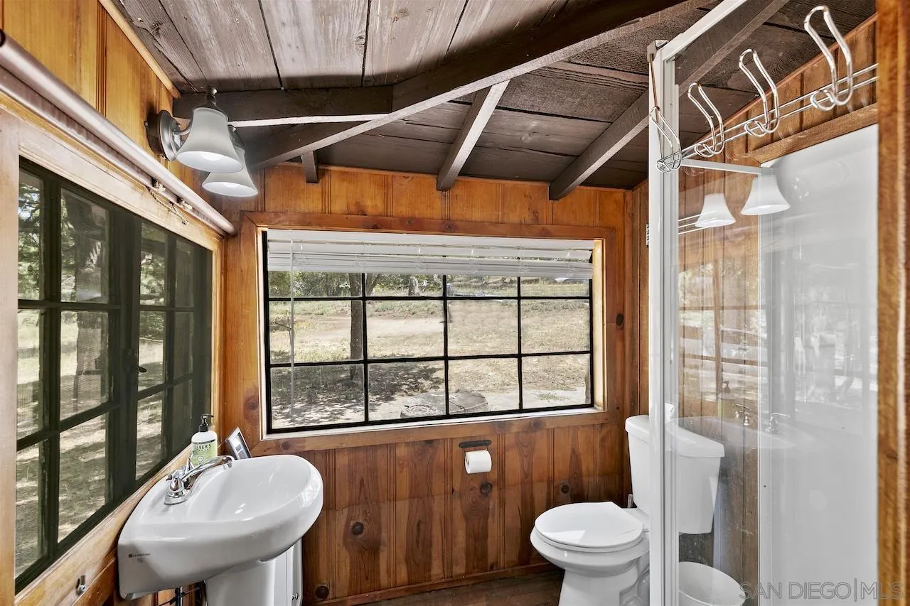 509 El Centro Terrace Mount Laguna, CA 91948 - Photo 17 of 23 a bathroom with a sink a toilet a mirror and a glass door shower