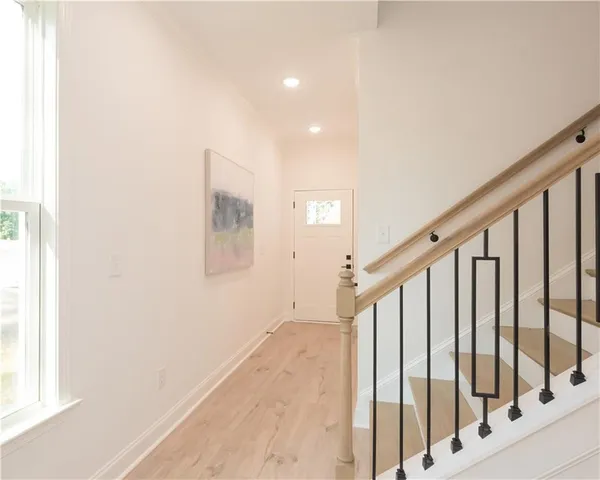 a view of staircase with lots of frames on wall and a window