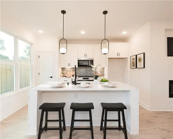 a kitchen with a dining table chairs a sink and cabinets