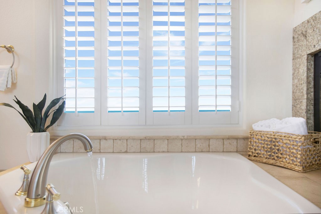 22 Callender Court Laguna Niguel, CA 92677 - Photo 32 of 67 a bathroom with a bathtub a sink a window and a shower