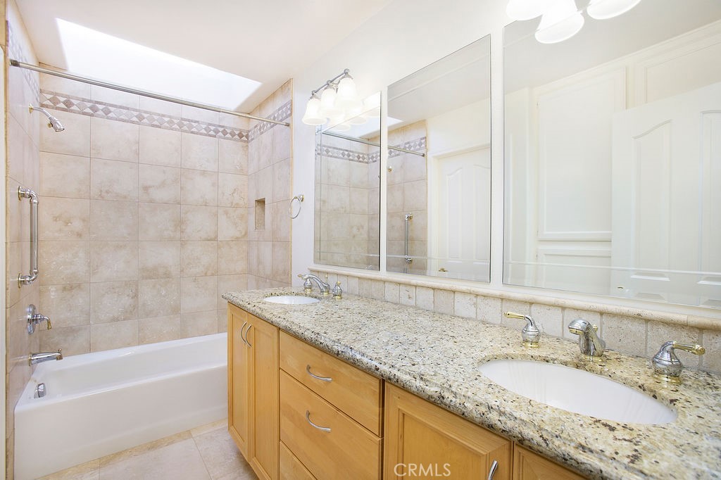 22 Callender Court Laguna Niguel, CA 92677 - Photo 38 of 67 a bathroom with a granite countertop sink a mirror a bathtub and shower