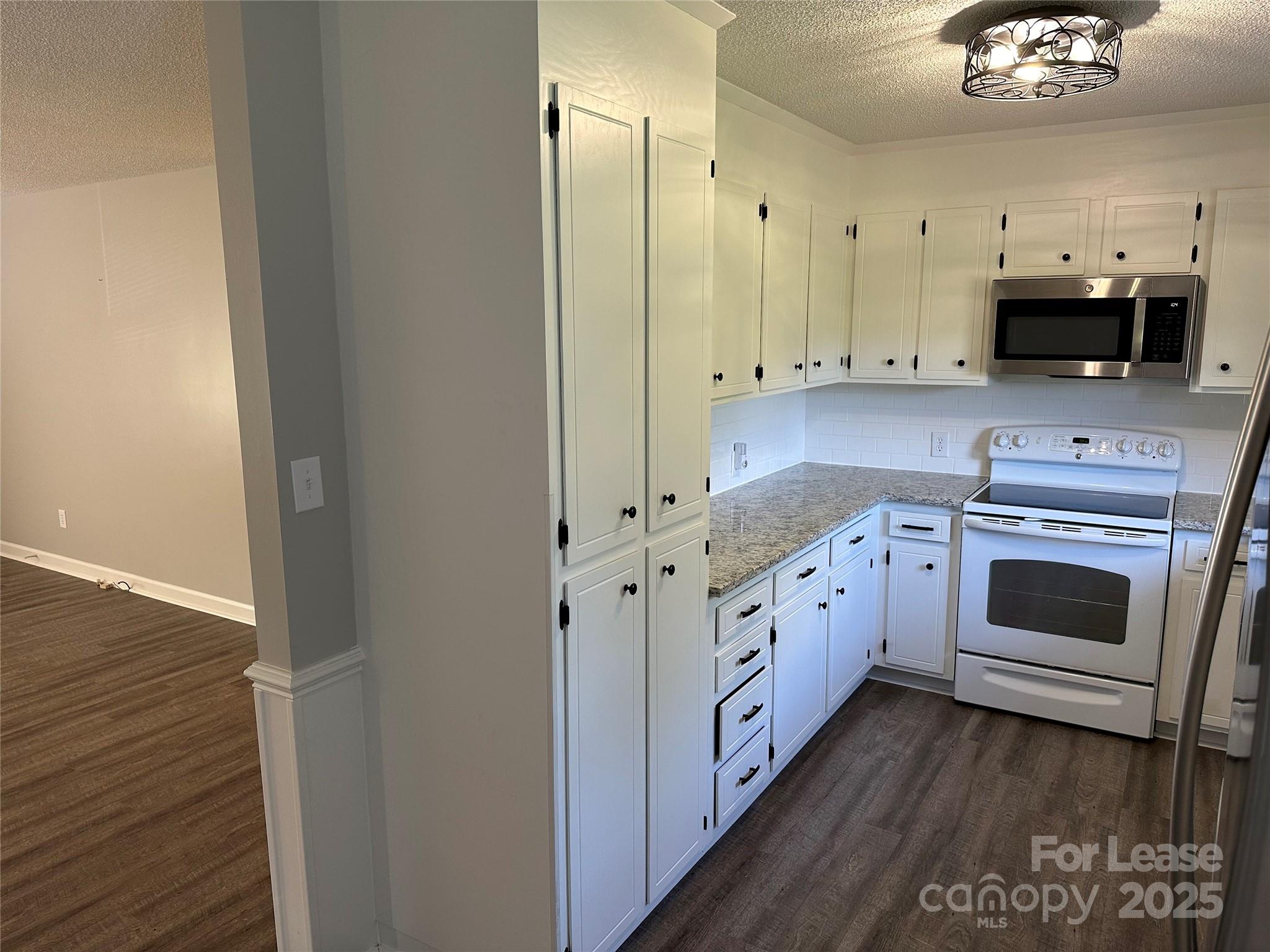 147 Sinclair Road Mooresville, NC 28115 - Photo 4 of 21 a large white kitchen with stainless steel appliances granite countertop a stove a sink and a refrigerator